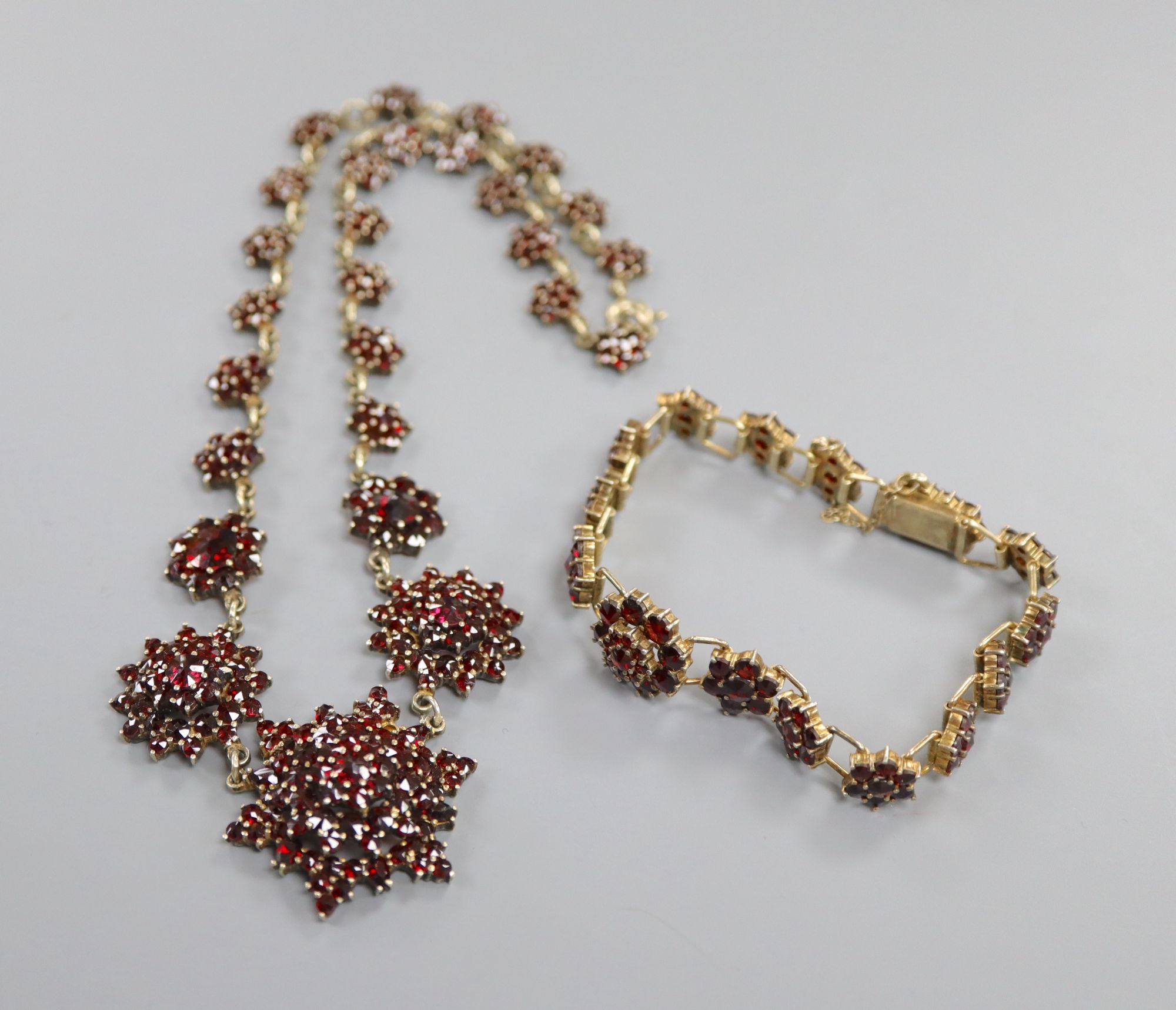 A 19th century gilt white metal and facet cut garnet set bracelet and similar necklace, 40cm.